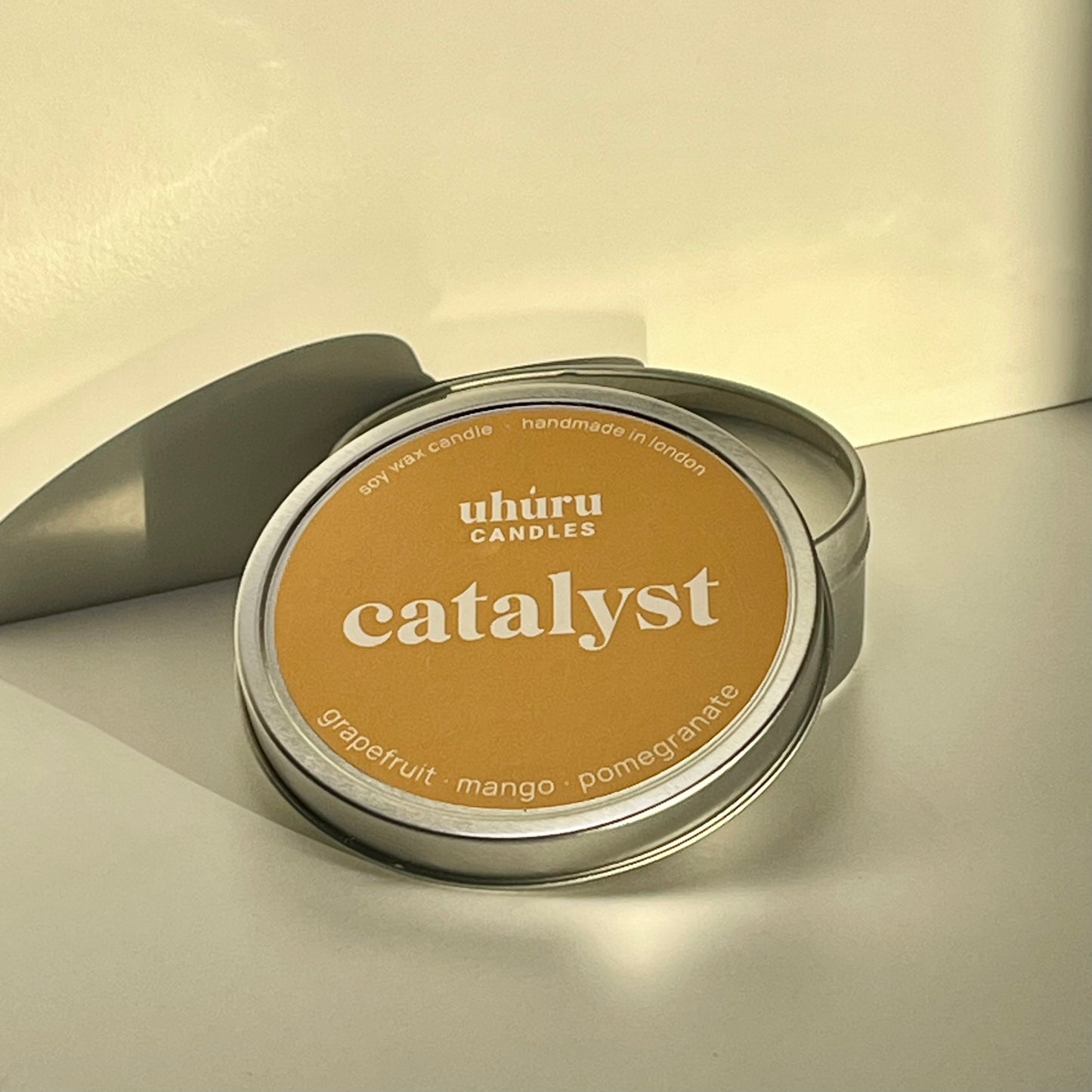 Catalyst by Uhuru Candles - grapefruit, mango and pomegranate scented soy wax candle in tin container. Net weight 70g.