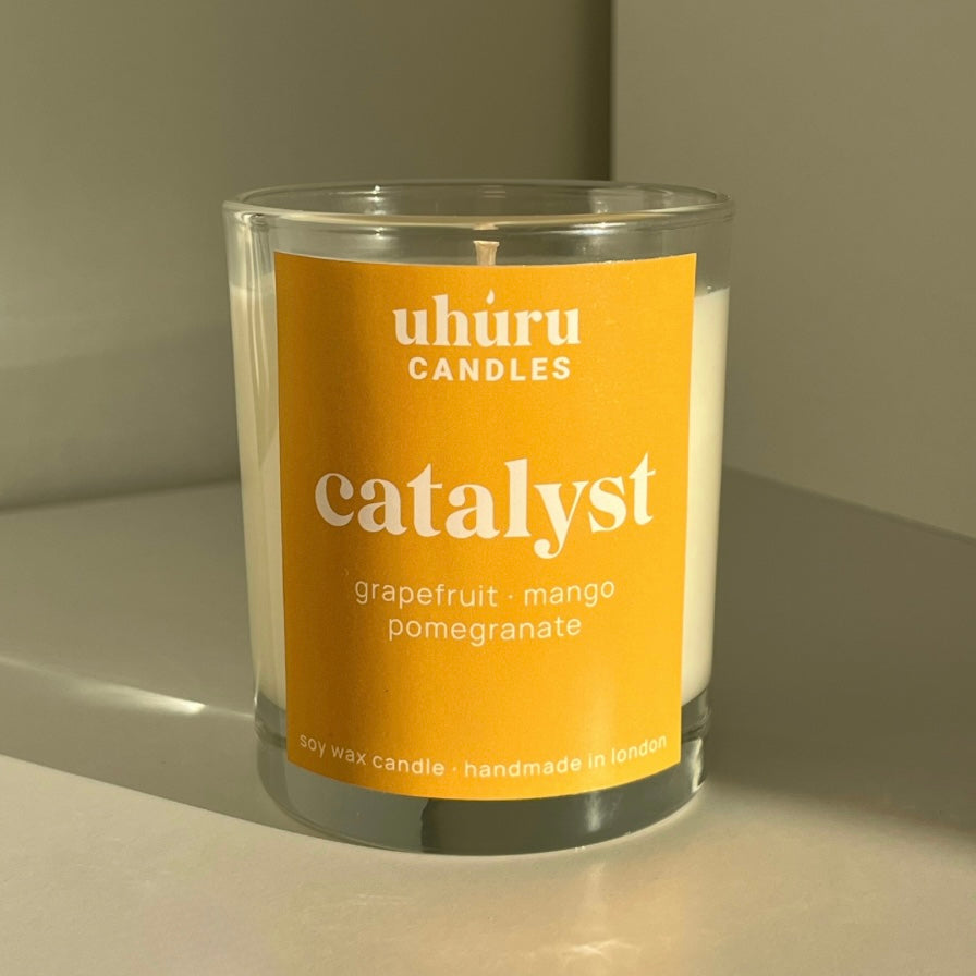 Catalyst by Uhuru Candles - grapefruit, mango and pomegranate scented soy wax candle in glass jar container. Net weight 150g.