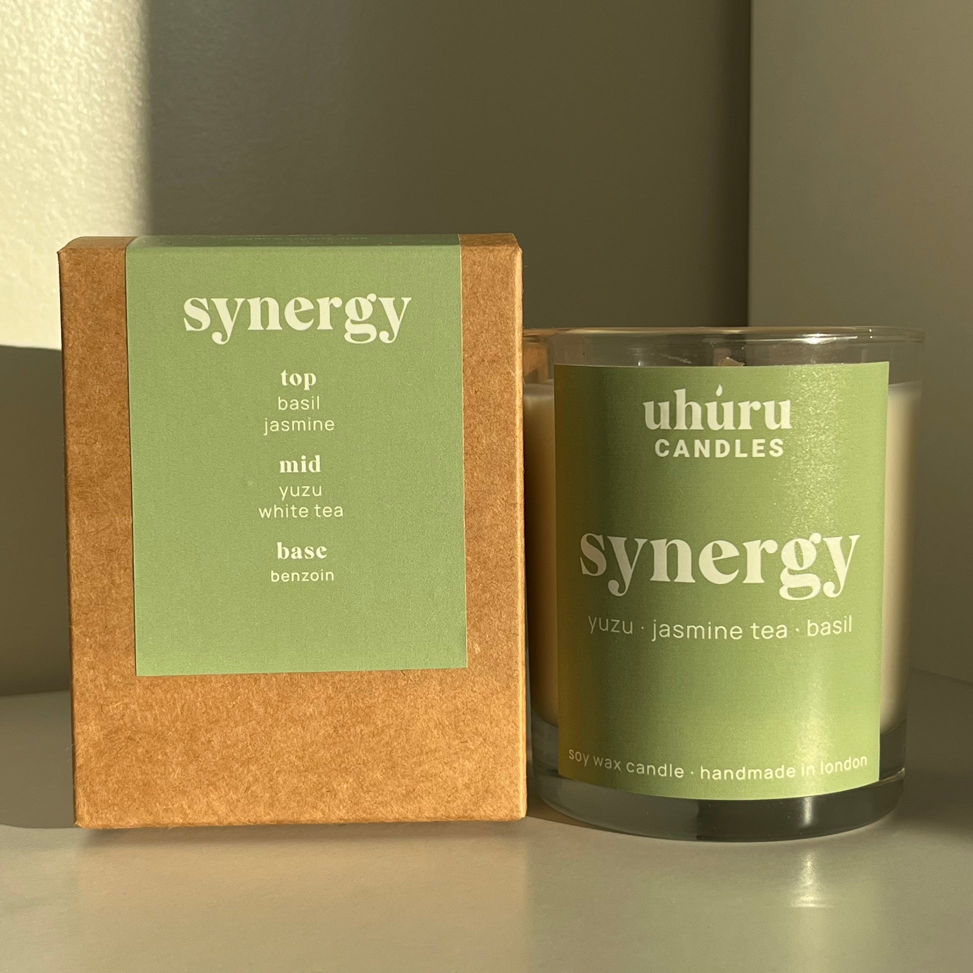 Synergy by Uhuru Candles with matching cardboard box packaging - yuzu, jasmine tea and basil scented soy wax candle in glass container. Jar net weight 150g.